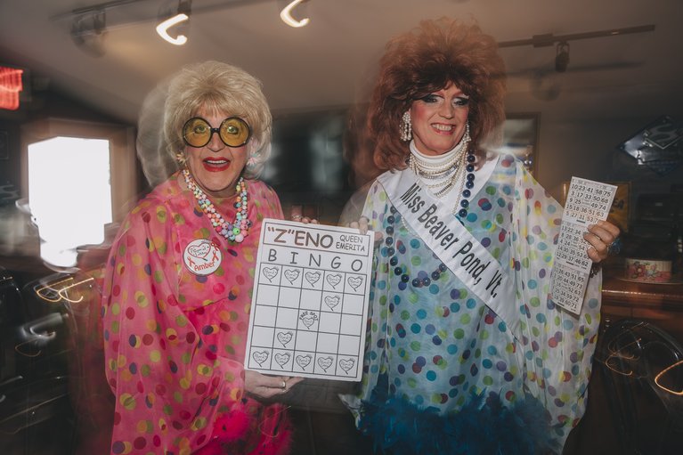 Drag queens showing their cards at the drag bingo event.