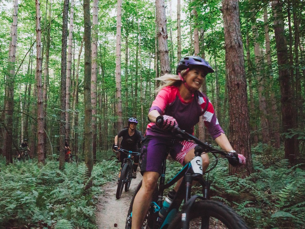 Elysa smiles widely as she bikes.