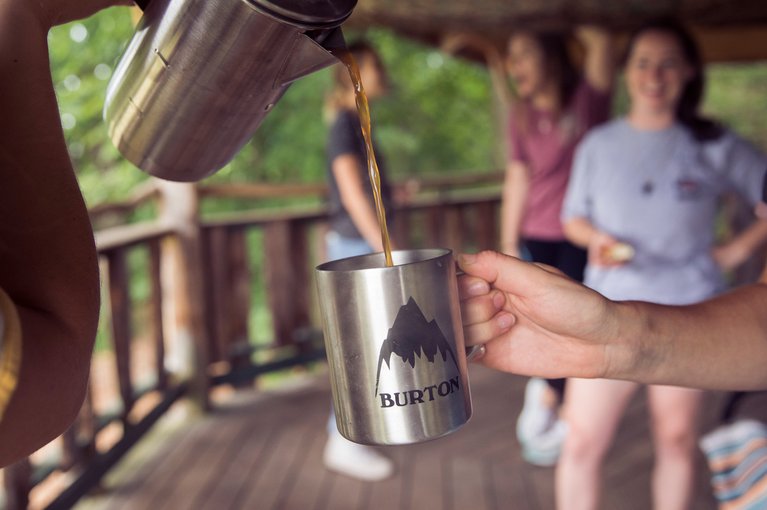 Coffee being poured into a Burton mug