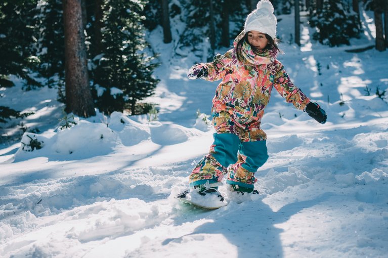 A young girl snowboarding